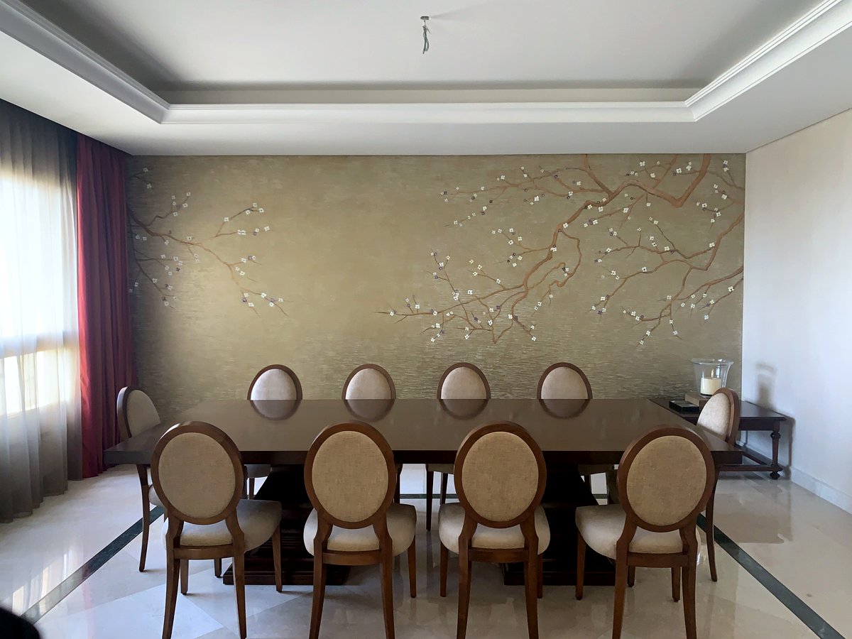 Dining room with a hand-painted blossom-branch mural on a gold-toned wall – Kassem Residence, Beirut