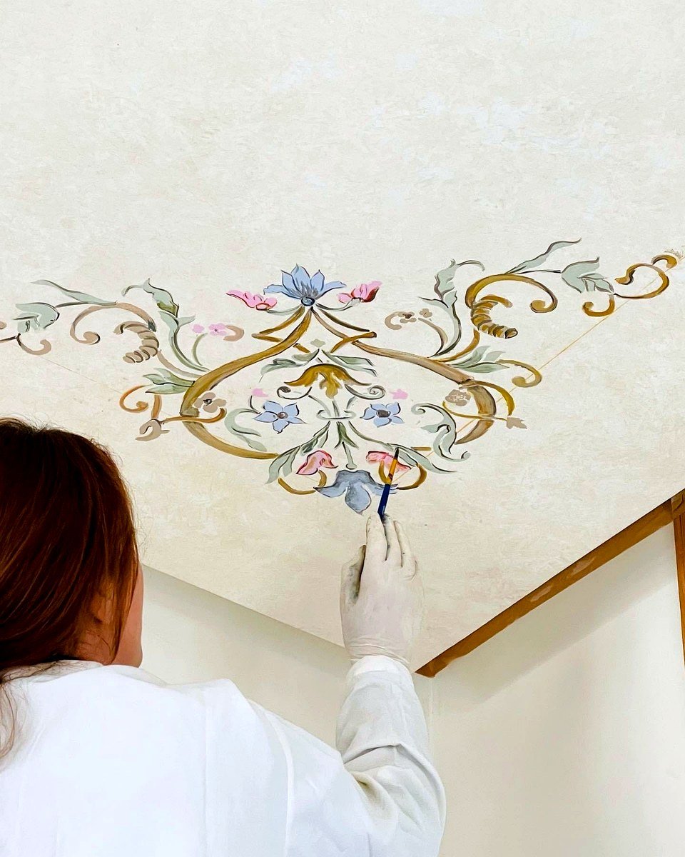Artisan painting a hand-painted ceiling medallion