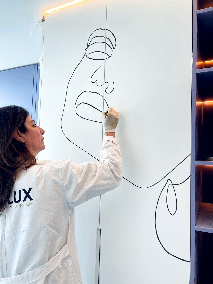 Artisan drawing fine line art on a wall